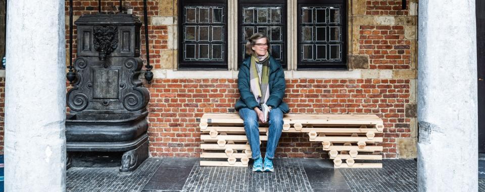 vrouw zit op een bankje, gemaakt door architectuurstudent, in de binnentuin van het museum 