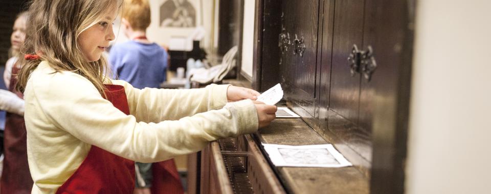 meisje aan het werk tijdens etsworkshop