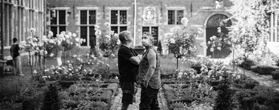 twee bezoekers met mondmasker in de binnentuin van Museum Plantin-Moretus