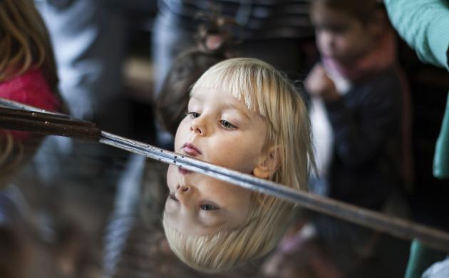 meisje kijkt in toonkast, dat lukt - door haar grootte - net