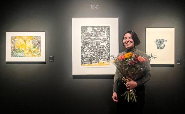 Winnaar Nasrim staat met een boeket bloemen bij haar inzending.