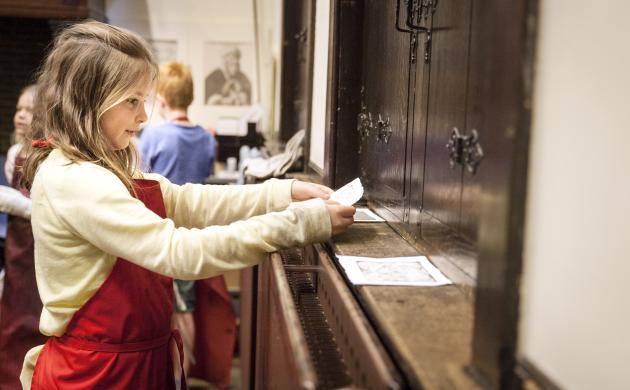 meisje aan het werk tijdens etsworkshop